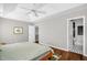Cozy bedroom with striped bedding, a ceiling fan, and an attached bathroom featuring modern fixtures at 11 Marsh Landing Ct, Durham, NC 27703