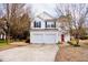 Charming two-story home featuring a well-maintained lawn, a two-car garage, and a welcoming red front door at 11 Marsh Landing Ct, Durham, NC 27703
