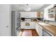 Sunlit kitchen featuring white cabinets, modern appliances, and a cozy rug on hardwood floors at 11 Marsh Landing Ct, Durham, NC 27703