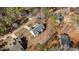 Overhead angle shows the home's layout and roofing features amidst its well-maintained grassy and wooded land at 112 Rawhide Dr, Louisburg, NC 27549