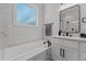 Bright bathroom with a soaking tub, modern vanity, and a window for natural light at 112 Rawhide Dr, Louisburg, NC 27549