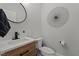 Stylish half bathroom with modern fixtures, wood-grain vanity, and decorative wall art at 112 Rawhide Dr, Louisburg, NC 27549