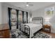 Bright bedroom featuring a wrought iron bed frame, neutral walls, and access to the back deck at 112 Rawhide Dr, Louisburg, NC 27549