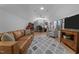 The bonus room features a comfortable leather couch, light gray armchair, baseball memorabilia, and a ceiling fan at 112 Rawhide Dr, Louisburg, NC 27549