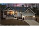 Beautifully landscaped home at dusk with a cozy front porch and attached two-car garage at 112 Rawhide Dr, Louisburg, NC 27549