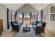 Relaxing screened-in porch with comfortable seating, stylish decor, and views of the wooded backyard at 112 Rawhide Dr, Louisburg, NC 27549