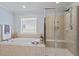 Bathroom featuring a soaking tub and glass enclosed shower with neutral tile at 1135 Rosepine Dr, Cary, NC 27519