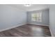 Bedroom with neutral walls and hardwood flooring illuminated by natural light at 1135 Rosepine Dr, Cary, NC 27519