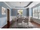 Staged dining room with elegant table setting, area rug, and modern artwork at 1135 Rosepine Dr, Cary, NC 27519