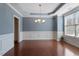 Traditional dining room with hardwood floors, wainscoting, and elegant chandelier at 1135 Rosepine Dr, Cary, NC 27519