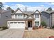 Charming two-story home with a stone facade, attached garage, and well-maintained front yard at 1135 Rosepine Dr, Cary, NC 27519