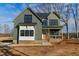 Beautiful two-story home featuring green and white siding, black framed windows, and a charming front porch at 1403 Antioch Church Rd, Timberlake, NC 27583