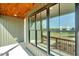 Covered porch featuring plank ceiling and large windows with views of surrounding land at 1403 Antioch Church Rd, Timberlake, NC 27583