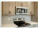 Well-equipped kitchen with stainless steel microwave and oven, tile backsplash, and wood cabinets at 1403 Antioch Church Rd, Timberlake, NC 27583