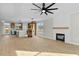 Bright open-concept living room with a fireplace, modern ceiling fan, and an adjacent kitchen at 1403 Antioch Church Rd, Timberlake, NC 27583