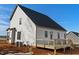 Rear exterior showcasing a white two-story home with a wooden deck, black framed windows, and dark roof at 1403 Antioch Church Rd, Timberlake, NC 27583