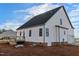 Back of a white two-story home featuring a wooden deck, a walk-out basement, and a two-car garage at 1403 Antioch Church Rd, Timberlake, NC 27583