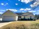 Charming single story home featuring an attached two car garage, manicured shrubs and green grass at 200 Lindell Dr, Apex, NC 27539