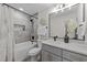 Updated bathroom featuring decorative mirror, white cabinets and shower with decorative tile at 2108 Rangecrest Rd, Raleigh, NC 27612