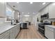 Open kitchen with gray cabinets, stainless appliances, quartz counters, and an eat-in bar at 2108 Rangecrest Rd, Raleigh, NC 27612