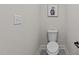 Clean, simple toilet for small space or powder room with neutral paint and modern art at 2108 Rangecrest Rd, Raleigh, NC 27612
