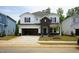 Two-story home with black and white siding, a two-car garage, and a well manicured yard at 2114 Cherry Creek Rd, Haw River, NC 27258