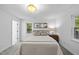Bright, cozy bedroom features a large bed, two windows, neutral walls, and grey carpeting at 2115 Port Royal Rd, Raleigh, NC 27609