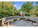 Spacious wooden deck with built-in benches, surrounded by lush greenery and mature trees, great for outdoor enjoyment at 2115 Port Royal Rd, Raleigh, NC 27609