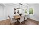 Dining room featuring modern lighting fixture, hardwood floors, and large windows at 2115 Port Royal Rd, Raleigh, NC 27609