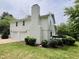 Side view of a two-story house with a white exterior, two-car garage, brick chimney and green lawn at 2115 Port Royal Rd, Raleigh, NC 27609