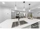 Bright kitchen featuring a large island, modern faucet, stainless steel appliances, and seamless flow to living and dining areas at 2115 Port Royal Rd, Raleigh, NC 27609
