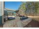 Inviting stone patio featuring lounge chairs, outdoor seating, and a built-in fire pit for cozy gatherings at 2128 Arborwood Dr, Durham, NC 27705