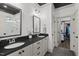 This bathroom features double sinks, a dark countertop, framed mirrors, and a large walk-in closet at 2128 Arborwood Dr, Durham, NC 27705