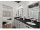 This bathroom features double sinks, a dark countertop, framed mirrors and a view to the bedroom at 2128 Arborwood Dr, Durham, NC 27705