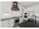 Bright kitchen featuring white cabinets, stainless steel appliances, and dark countertops, perfect for cooking and entertaining at 2128 Arborwood Dr, Durham, NC 27705