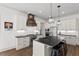 Bright kitchen with white cabinets, black countertops, stainless steel appliances, and an island with barstool seating at 2128 Arborwood Dr, Durham, NC 27705