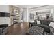 Open-concept living room with stacked stone fireplace, kitchen access, and wood-look flooring at 2128 Arborwood Dr, Durham, NC 27705