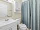 This bathroom features a white sink and vanity, a toilet, storage, and a tub with a light blue shower curtain at 228 Finley Forest Dr, Chapel Hill, NC 27517