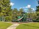 Community playground featuring play set, surrounded by green space and trees at 228 Finley Forest Dr, Chapel Hill, NC 27517