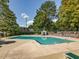 Community pool surrounded by trees, lounge chairs, and a deck at 228 Finley Forest Dr, Chapel Hill, NC 27517
