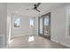 Well-lit bedroom featuring hardwood floors, a ceiling fan, and glass doors to a private balcony at 228 Woodsborough Pl, Raleigh, NC 27601