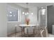 Bright dining area features a modern chandelier and a marble table with seating for four at 228 Woodsborough Pl, Raleigh, NC 27601