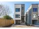 Modern three-story home with sleek lines and a glass garage door at 228 Woodsborough Pl, Raleigh, NC 27601