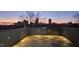 Stunning rooftop deck with pavers and a cityscape view at sunset at 228 Woodsborough Pl, Raleigh, NC 27601