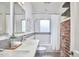 Bright bathroom featuring dual sinks, a subway-tiled shower, and exposed brick accents at 2618 Elgin St, Durham, NC 27704