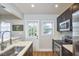 Bright kitchen featuring stainless steel appliances, dark cabinets, and access to the backyard at 2618 Elgin St, Durham, NC 27704