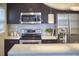 Modern kitchen with stainless steel appliances, dark cabinets, and a stylish tiled backsplash at 2618 Elgin St, Durham, NC 27704