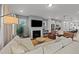 Open-concept living room with a fireplace, flat-screen TV, and a seamless flow to the modern kitchen at 283 Dry Canyon Dr, Wendell, NC 27591