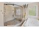 Bright bathroom featuring a glass-enclosed shower and a soaking tub, perfect for relaxation at 2920 Claremont Rd, Raleigh, NC 27608