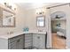 Bathroom with dual sinks, gray cabinets, and large mirrors; stylish and functional at 2920 Claremont Rd, Raleigh, NC 27608